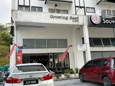 two cars parked in front of a growling seed cafe at Cozystay @ The Quintet, Cameron in Tanah Rata