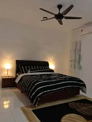 a bedroom with a bed and a ceiling fan at AWANA HOMESTAY in Sungai Petani