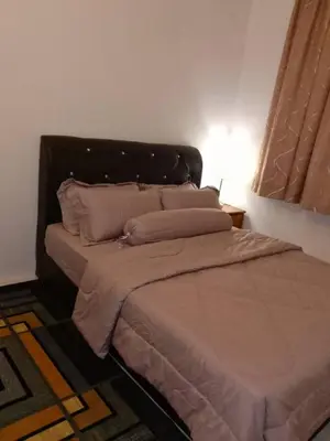 a bedroom with a large bed with a headboard at AWANA HOMESTAY in Sungai Petani