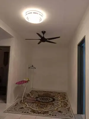 a ceiling fan in a room with a rug at AWANA HOMESTAY in Sungai Petani