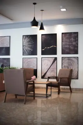 a room with two chairs and paintings on the wall at Sunstone Hotel in George Town