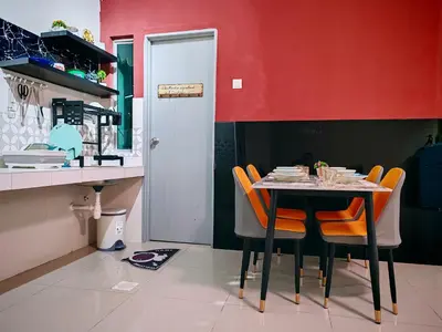 a dining room with a table and orange chairs at Pavilionvillie M1T583 by irainbow in Kampong Kepayang