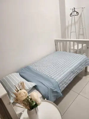 a bed with a blue blanket and a table at NORDIC SKYHOME Ipoh in Kampong Ulu Chepor