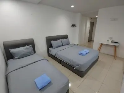 two beds in a room with blue pillows at 184 GURNEY DRIVE PENANG in George Town