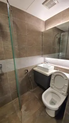 a bathroom with a toilet and a sink at Sunrise Gurney By IZ in George Town