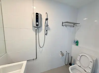 a white bathroom with a shower and a toilet at Sunrise Gurney By IZ in George Town