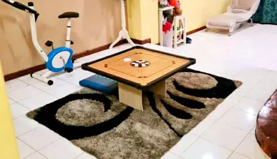 a living room with a table and a treadmill at D'Serina Homestay-3 bedroom 6 bed & free parking in Sungai Petani