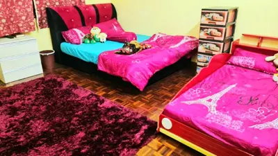 a bedroom with two beds and pink sheets at D'Serina Homestay-3 bedroom 6 bed & free parking in Sungai Petani