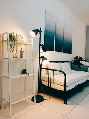 a bedroom with a bed and a lamp and shelves at Beacon Executive Suites 2BR at Georgetown by WL in George Town