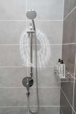 a shower with a shower head in a bathroom at Ipoh Tambun Lost World Sunway Onsen Suites Luna 2R2B 8paxs in Ipoh