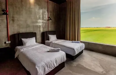two beds in a room with a view of a field at PADI Sentral @ Sekinchan in Sekincan