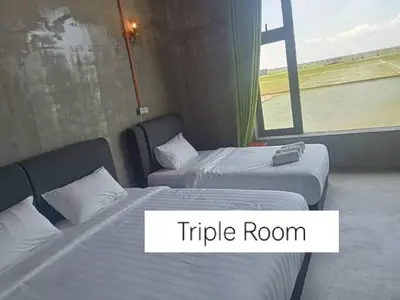 a hotel room with two beds and a window at PADI Sentral @ Sekinchan in Sekincan