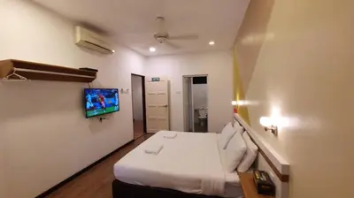 a hotel room with a bed and a flat screen tv at Landed Home near Gurney and Georgetown for 18pax WL in George Town