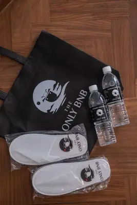 a bag and two bottles of water on a table at Deluxe Seaview Suite King Bed by The Only Bnb in Tanjong Tokong