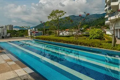 a large swimming pool with a view of a city at Deluxe Seaview Suite King Bed by The Only Bnb in Tanjong Tokong
