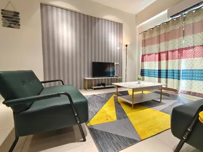 a living room with a green chair and a table at Pavilionvillie M1T572 by irainbow in Ipoh