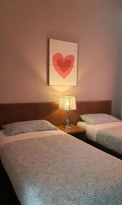 two beds in a room with a heart painting on the wall at G Residence - 3R2B The Retreat, Aranda Nova, Cameron Highlands in Cameron Highlands