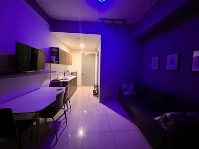 a purple living room with a couch and a table at BLUE JADE STUDIOS in Tanah Rata