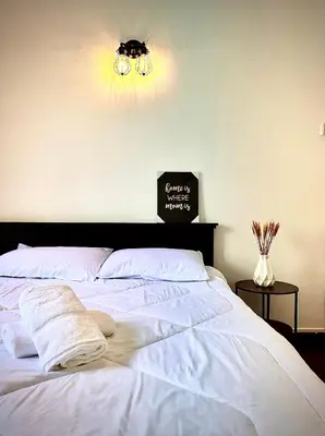 a bedroom with a white bed with a black headboard at Ipoh Deluxe Family Home in Ipoh