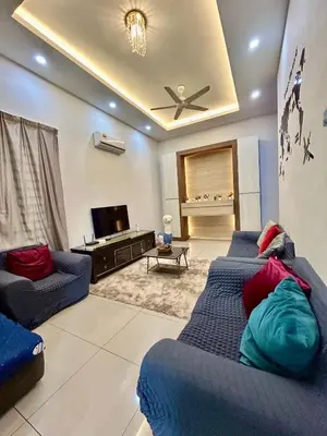 a living room with two blue couches and a tv at Comfort 36 Entire House At Alma Bukit Mertajam in Bukit Mertajam