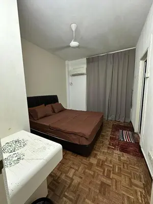 a small bedroom with a bed and a table at Bayu Emas Ferringhi Homestay in Batu Ferringhi