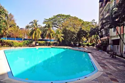 a large blue swimming pool next to a building at Bayu Emas Ferringhi Homestay in Batu Ferringhi