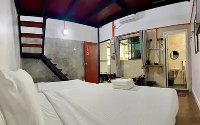a bedroom with two beds and a staircase in it at Ardour Lodge 
