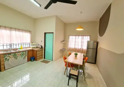 a kitchen with a table and a refrigerator at Air-home No 9 Kampung Boyan, 4BR, 9pax, Netflix in Taiping