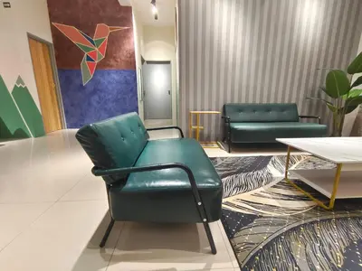 a waiting room with a green chair and a table at Pavilionvillie M1T11 by irainbow in Simpang Pulai