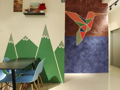 a table and chairs in a room with a mountain mural at Pavilionvillie M1T11 by irainbow in Simpang Pulai
