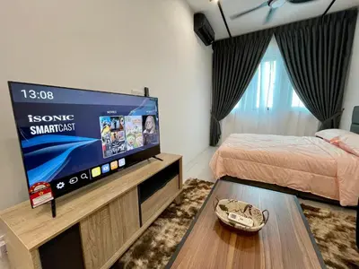 a bedroom with a large flat screen tv in a room at Cozy Suite Studio Meritus Residensi Perai in Perai
