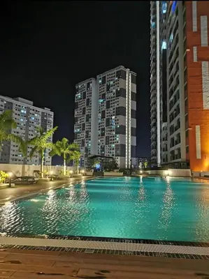 a large swimming pool in a city at night at Cozy Suite Studio Meritus Residensi Perai in Perai