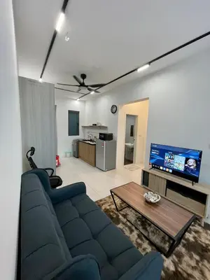 a living room with a blue couch and a tv at Cozy Suite Studio Meritus Residensi Perai in Perai