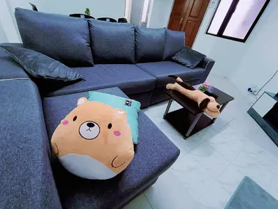 a living room with a blue couch with a bear pillow at Jo-Rumah 3 Bedroom Apartment Jelutong Georgetown Penang Free WIFI in Jelutong