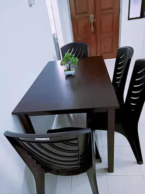a wooden table and chairs with a plant on it at Jo-Rumah 3 Bedroom Apartment Jelutong Georgetown Penang Free WIFI in Jelutong