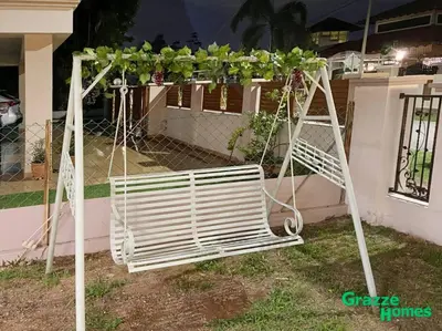 a swing with plants on it in front of a house at Ipoh Town Bangalow Canning Garden Football Table in Ipoh