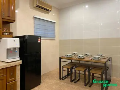 a kitchen with a table and a black refrigerator at Ipoh Town Bangalow Canning Garden Football Table in Ipoh