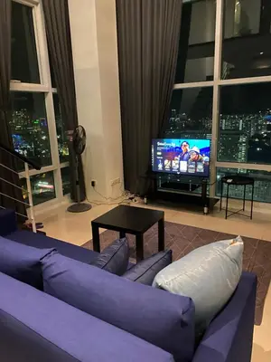 a living room with a purple couch and a tv at MARITIME SUITES DUPLEX MARVELOUS SEA VIEW in George Town