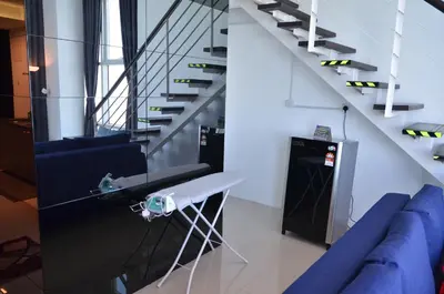 a living room with a blue couch and stairs at MARITIME SUITES DUPLEX MARVELOUS SEA VIEW in George Town