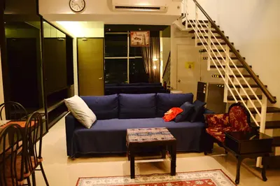 a living room with a blue couch and a staircase at MARITIME SUITES DUPLEX MARVELOUS SEA VIEW in George Town