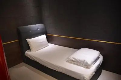 a small bed with white sheets and pillows on it at MARITIME SUITES DUPLEX MARVELOUS SEA VIEW in George Town