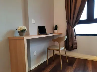 a desk with a laptop and a chair next to a window at Onsen Suite at Sunway Lost World Tambun in Ipoh