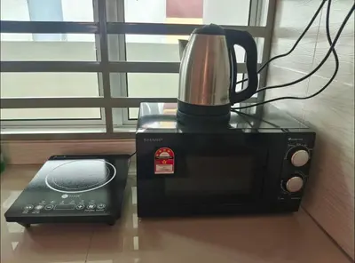 a black microwave with a coffee pot on top of it at ZaraVip homestay in Lahat