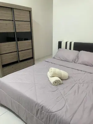 a white towel laying on top of a bed at ZaraVip homestay in Lahat