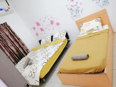 two beds in a room with a box at Destiny Homestay in Sungai Petani