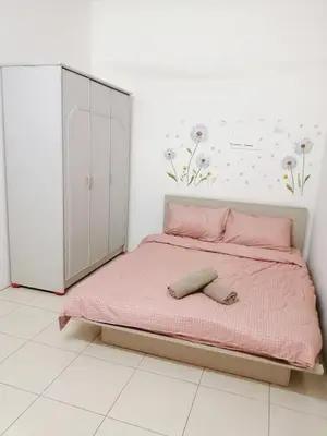 a bedroom with a pink bed and a cabinet at Destiny Homestay in Sungai Petani