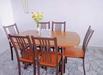 a wooden table with chairs and a vase of flowers on it at Destiny Homestay in Sungai Petani
