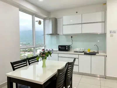 a kitchen with a table with a vase of flowers on it at Apartment@Mansion One Georgetown in George Town
