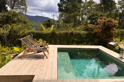 a swimming pool with a chair and a chair istg at The White Horse in Cameron Highlands