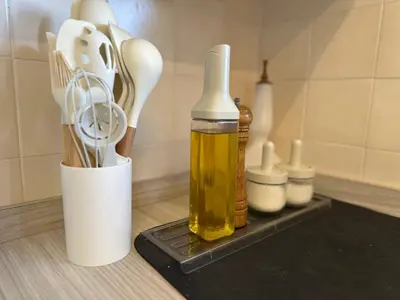 a counter with a bottle of oil and some kitchen utensils at The White Horse in Cameron Highlands